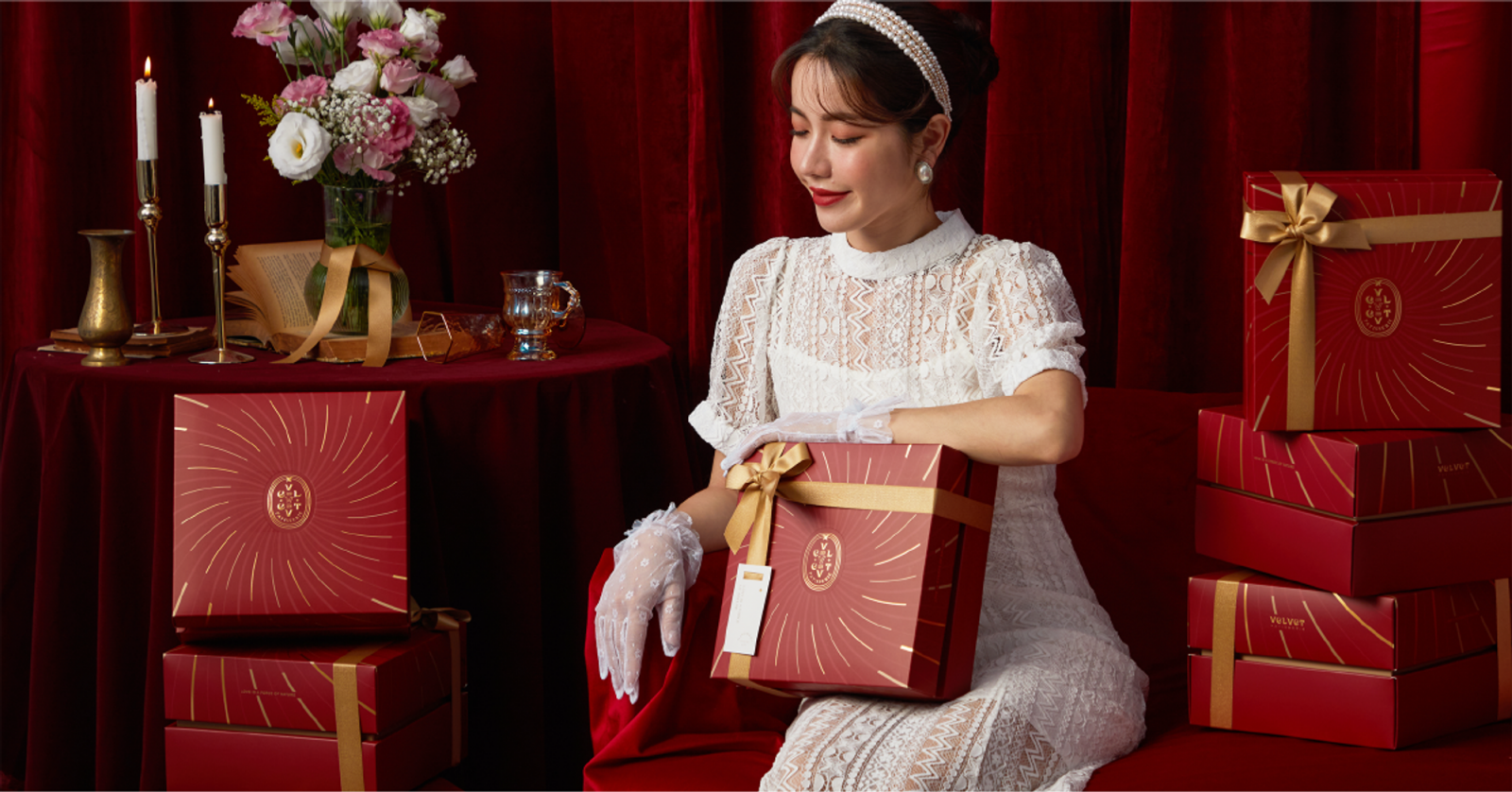 盛放紅色禮盒與金色緞帶、新娘及紅色布幔